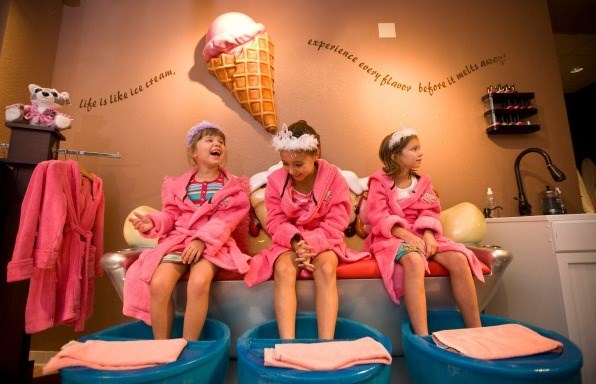 बच्चे don pink robes and tiaras at the ice cream-themed Scooops Spa at Great Wolf Lodge.