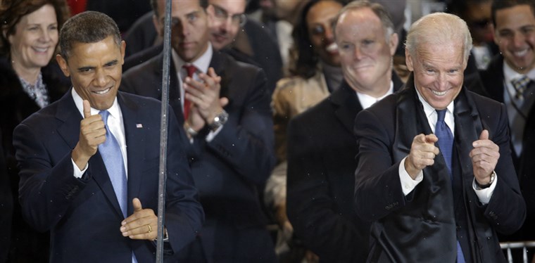 Helyettes President Joe Biden gives the thumbs up and the finger point as he and President Barack Obama react during the inaugural parade on Pennsylvania Avenue near the White House on Monday.