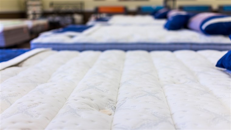 क्लोज़ अप of many mattresses on display in store