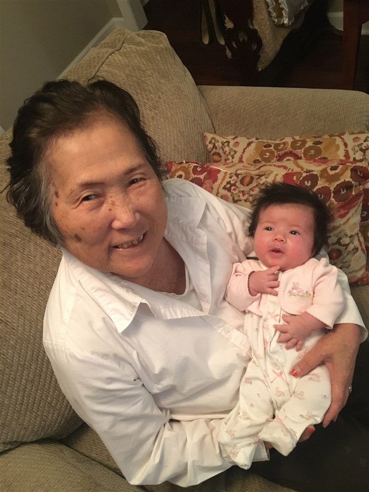 अल्जाइमर's patient Setsuko Harmon cradles her granddaughter Sadie.