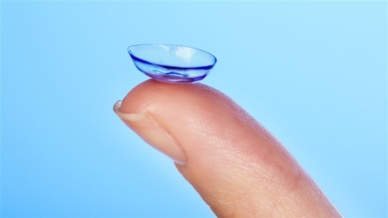 איש קשר lens on finger on blue background