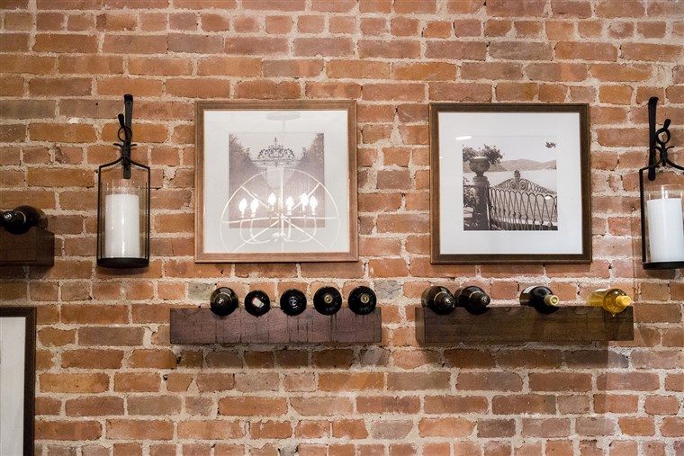 Dylan and her husband decided to store their wine bottles by creating a wine display on an exposed brick wall near the kitchen.