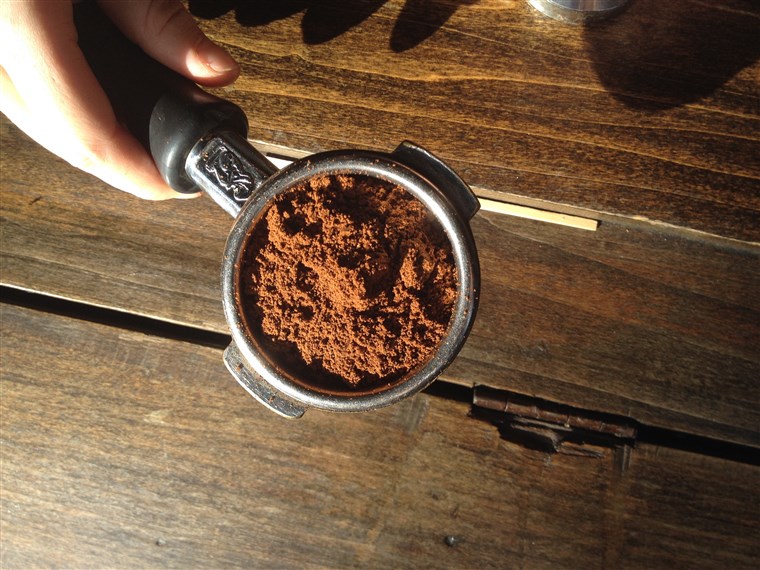 परिश्रम के साथ अध्ययन coffee beans into a fine powder to make espresso