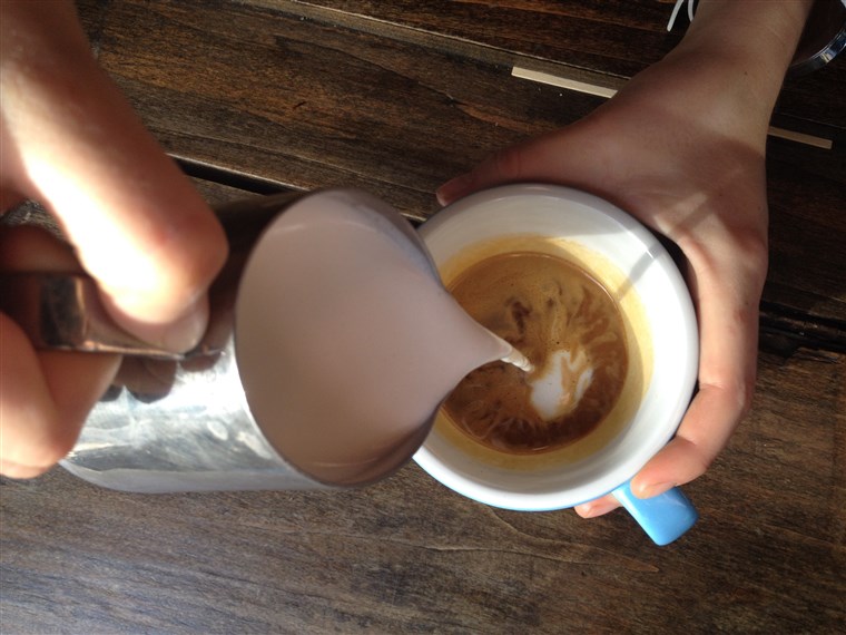 önt a dollop of steamed milk into espresso
