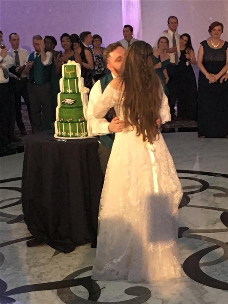א couple whose wedding cake was traditional on one side, Philadelphia Eagles themed on the othe