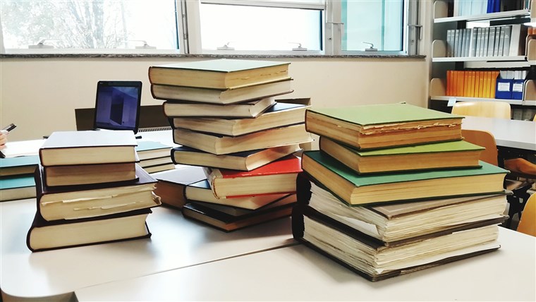 תמונה: Close-Up Of Hardcover Book Stacks On Table In Library