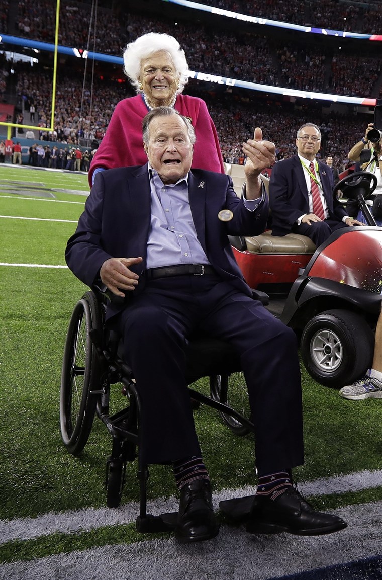 לשעבר President George H.W. Bush tosses the coin as his wife, Barbara, watches before the NFL Super Bowl 51