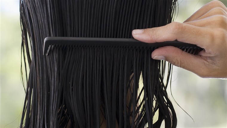 אישה combing hair, rear view