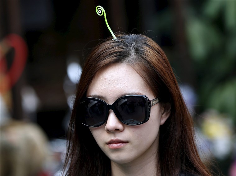 ए woman wearing a sprout-like hairpin makes her way on Nanluoguxiang street in Beijing