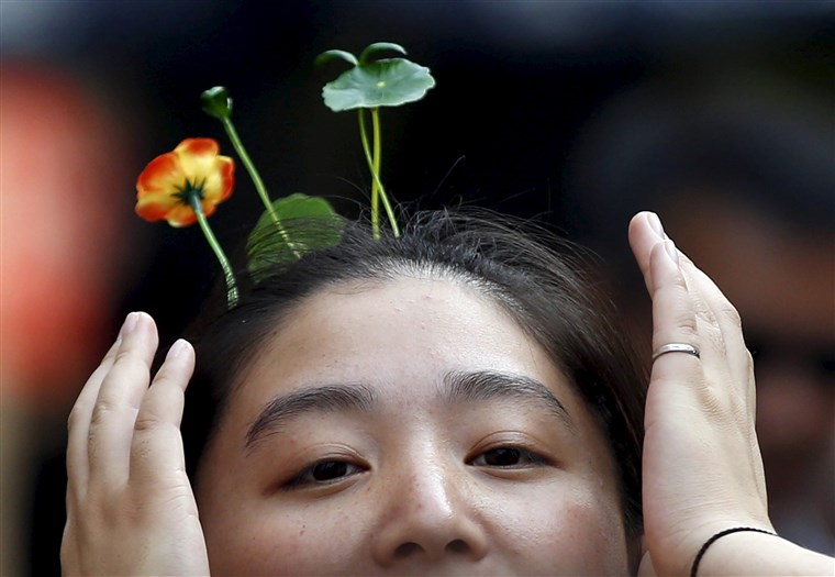 ए woman wearing hairpins in the shape of sprouts and flowers makes her way on Nanluoguxiang street in Beijing