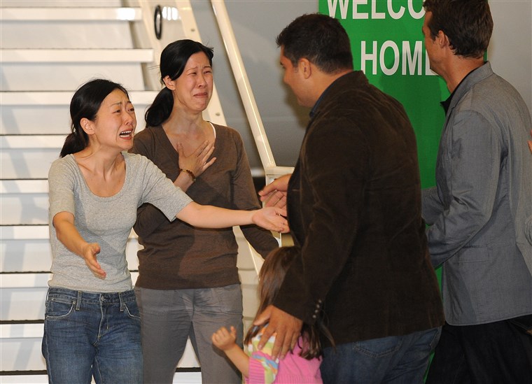 Euna Lee and Laura Ling embrace their family after being released from North Korea in 2009.