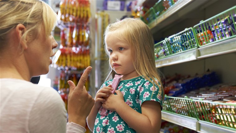 ילדה Having Argument With Mother At Candy Counter In Supermarket.
