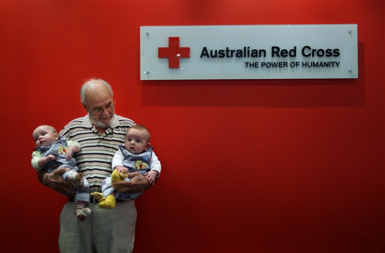 चित्र of James Harrison 72 (centre) with twin boys Seth Murray O+ (left) and Ethan Murray O-(right) in the Apheresis department at the Australian Red Cross Blood Service. Hundreds of thousands of babies owe their health and in some cases their life to James Harrison as his blood has been used in every dose of anti-D serum since 1967, which is given when the blood types of mothers and babies are incompatible. Red Cross, Sydney, NSW. Today 20th of May, 2009. Photo by KATE GERAGHTY.