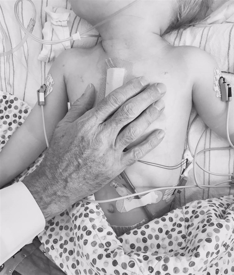 डॉ Thomas Spray's hand over Finn's heart, moments after surgery.