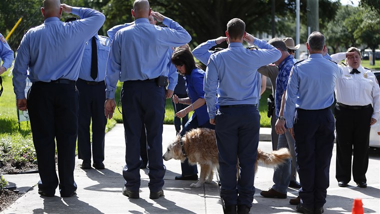 Bretagne the last surviving search and rescue dog from 9/11 is walked by her handler Denise Corliss past a flank of members of the Cy-Fair Volunteer Fire Department