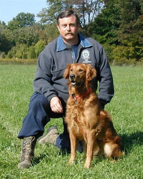 टेरी Trepanier, a career firefighter, is pictured in 2002 with his search dog, Woody.