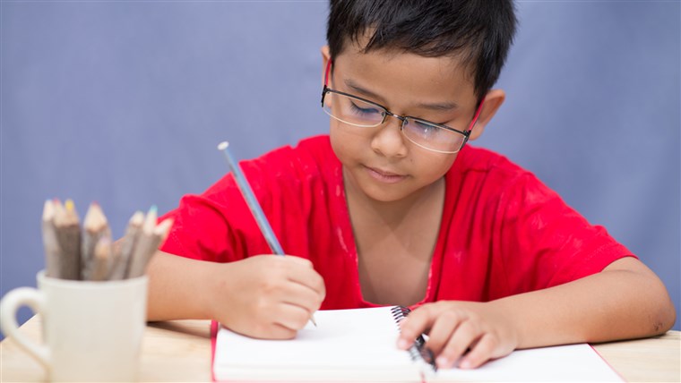 ילד writing in notebook