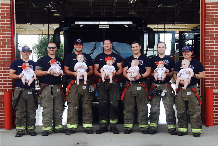 सात firefighters with their babies pose for picture