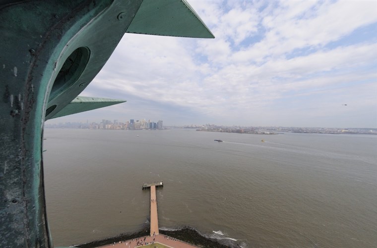 आगंतुकों to the crown of the Statue of Liberty get a great look at New York Harbor.