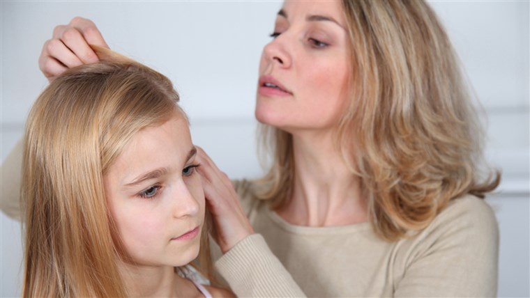 Majka treating daughter's hair against lice