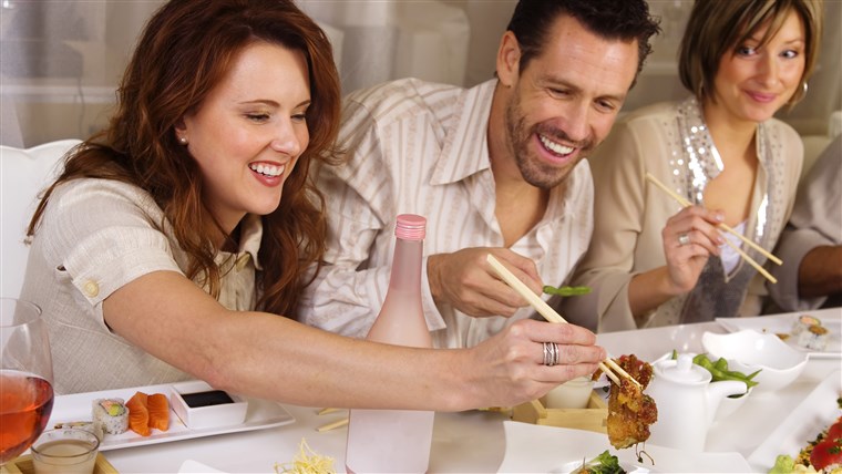 קבוצה of attractive people eating and socializing at a restaurant