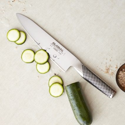 שף's knife cutting cucumbers