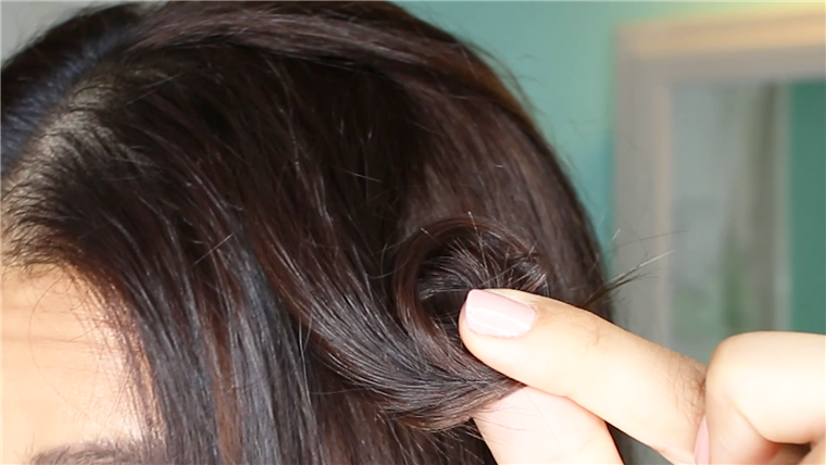 צור pin curls by winding 2-inch sections of hair around your finger.