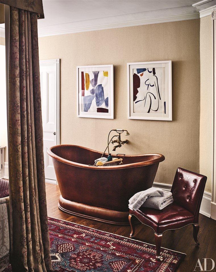 א copper pedestal tub makes a style statement in the master bedroom.