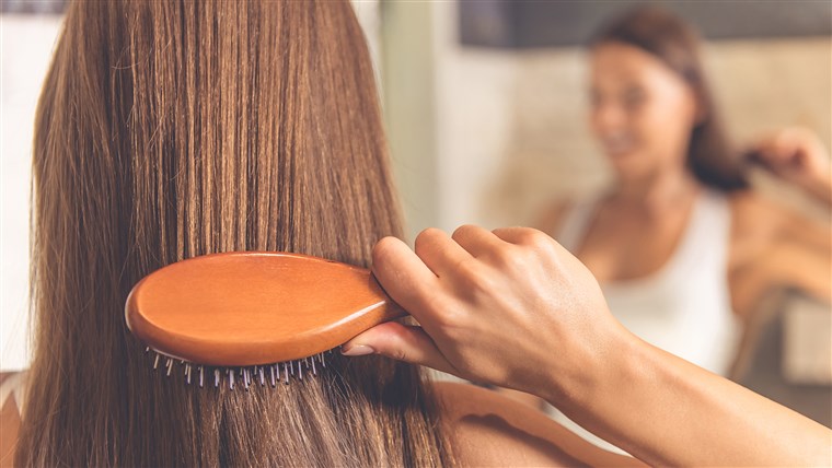 चमकदार Hair - Woman combing her hair.