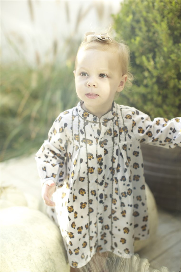 एक cool baby wears a leopard-print onesie by Trico Field.