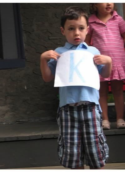 Dječak holding a K sign